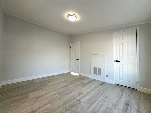 a view of an empty room with wooden floor