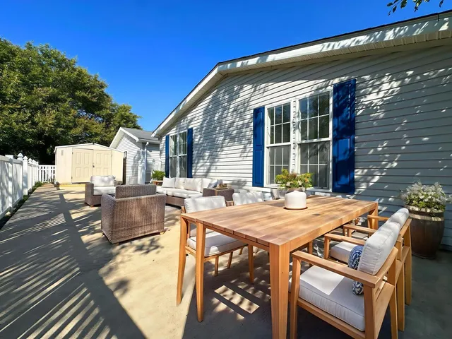 a view of a patio with table and chairs with wooden floor and fence