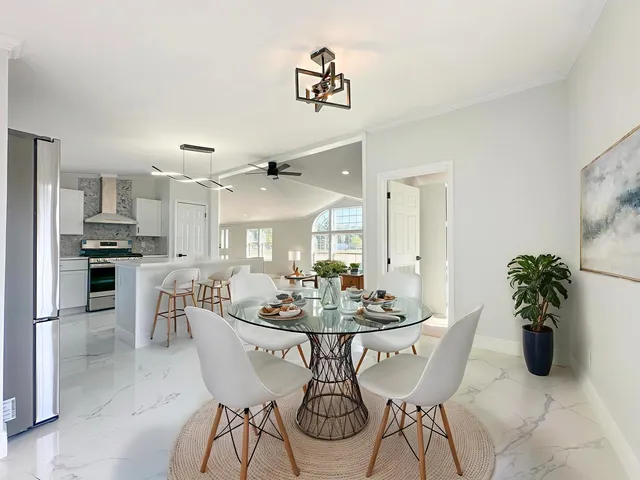 a dining room with furniture potted plants and wooden floor