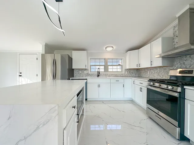 a kitchen with white cabinets appliances and a sink