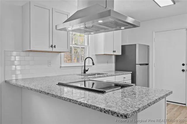a kitchen with stainless steel appliances granite countertop a sink a refrigerator and a granite counter tops