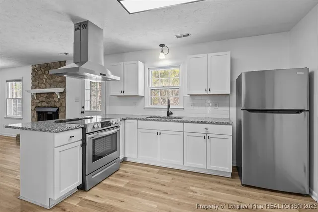 a kitchen with granite countertop a sink stainless steel appliances and cabinets