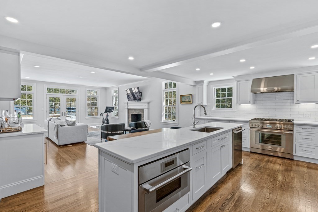 71 Fuller Brook Road Wellesley, MA 02482 - Photo 7 of 24 a kitchen with stainless steel appliances granite countertop a stove top oven a sink dishwasher a dining table and chairs with wooden floor