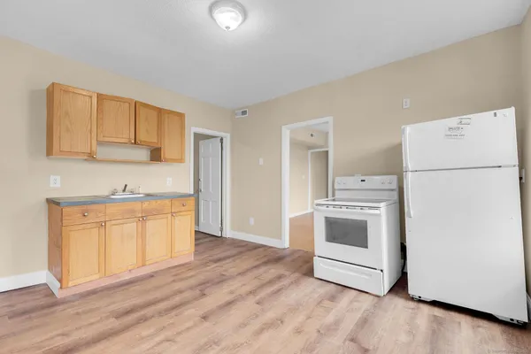 a kitchen with granite countertop white cabinets and white appliances