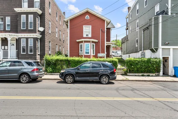 a car parked in front of a big house