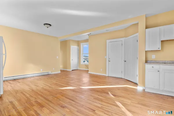 a view of an empty room with wooden floor