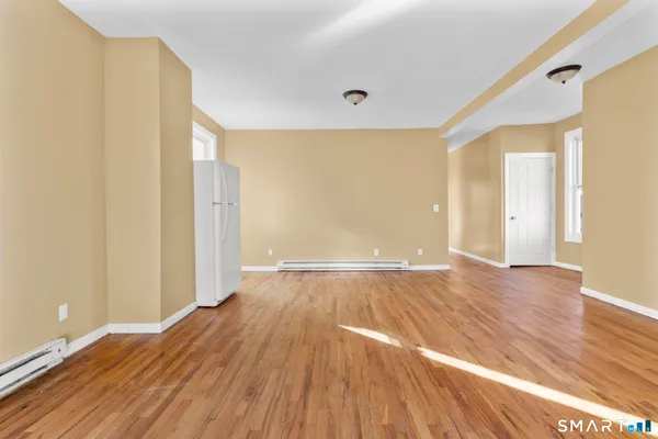 a view of an empty room with wooden floor