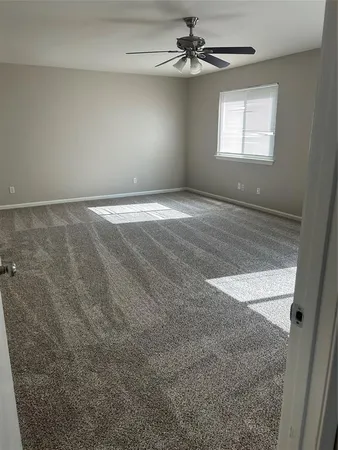 an empty room with windows and fan view