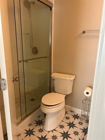 a bathroom with a toilet and a shower