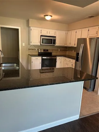 a kitchen with stainless steel appliances a refrigerator a stove a microwave a sink and a counter