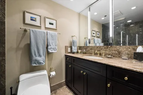 a bathroom with a granite countertop sink toilet and shower