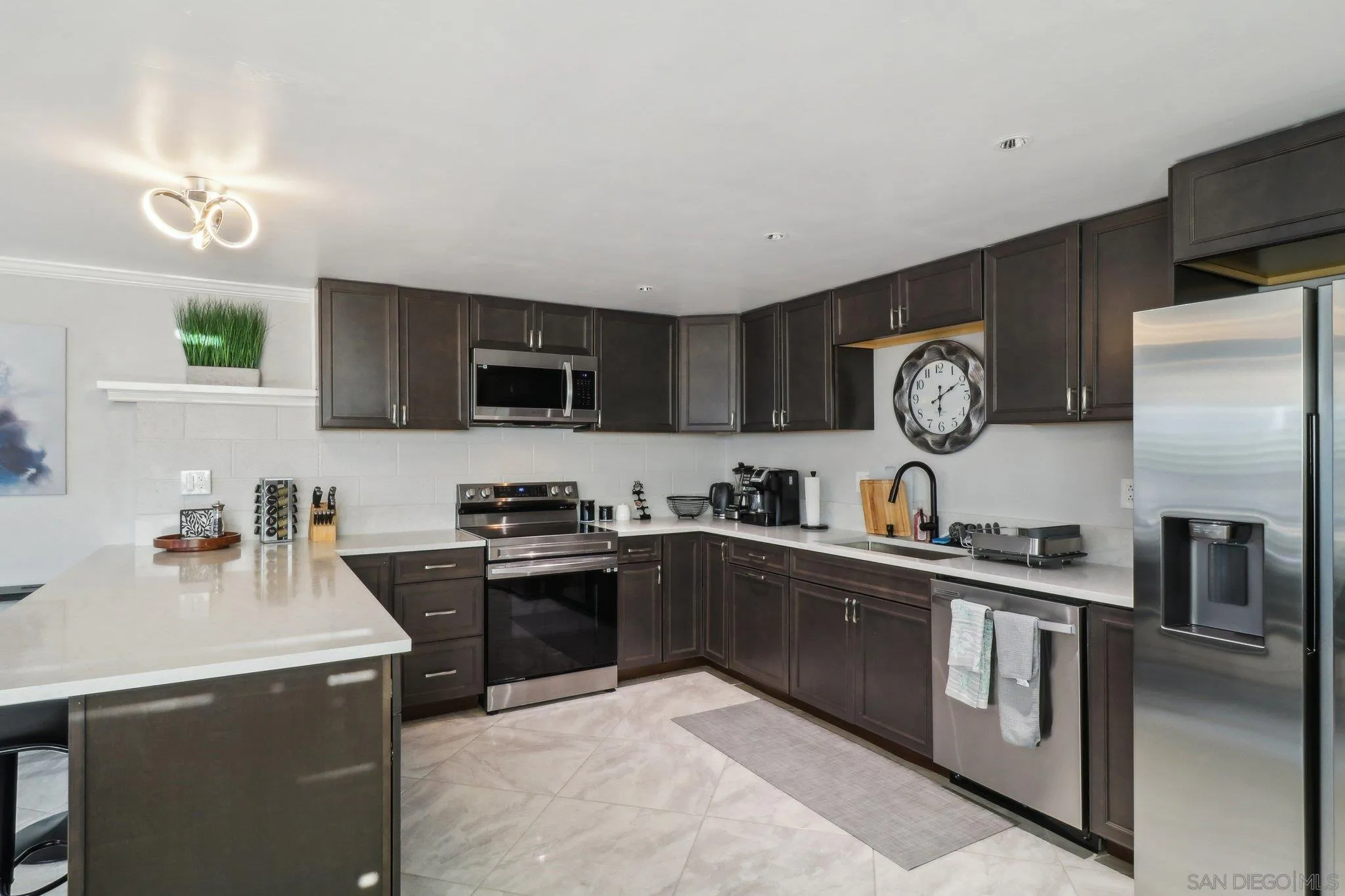 10420 Loma Rancho Drive Spring Valley, CA 91978 - Photo 31 of 41 a kitchen with stainless steel appliances granite countertop a stove top oven a sink dishwasher and a refrigerator with wooden floor