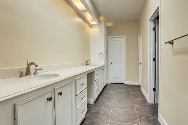 a spacious bathroom with a granite countertop sink a mirror and a