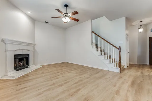 a view of an empty room with chandelier and fireplace