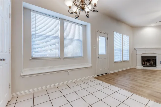a view of an empty room with a window and fire place