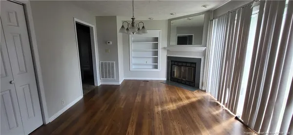 a view of a hallway with wooden floor and a fireplace