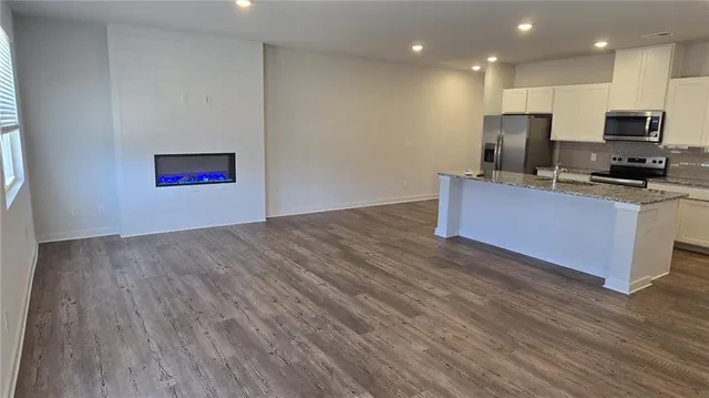 a kitchen with stainless steel appliances wooden floors and view living room