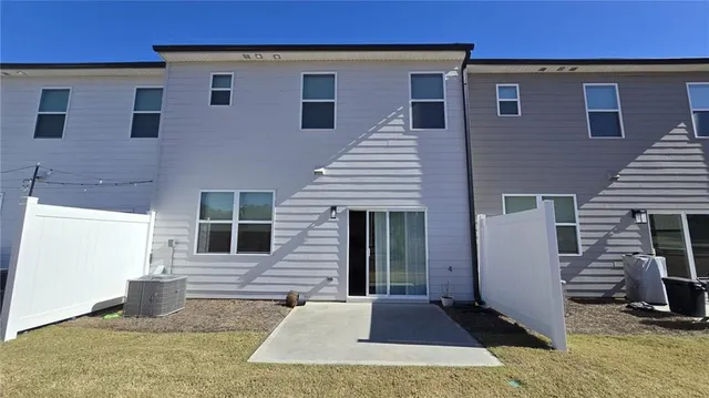 a view of a house with a barbeque and wooden stairs