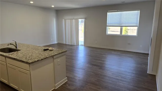 a kitchen with granite countertop wooden floors and wide window