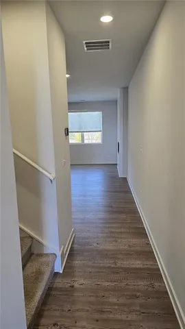 a view of a hallway with wooden floor