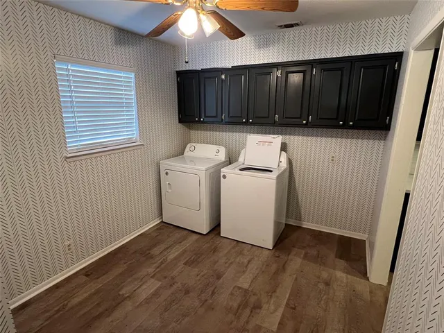 a utility room with wooden floor washer and dryer