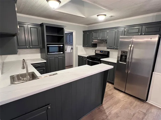 a kitchen with stainless steel appliances a refrigerator and a sink