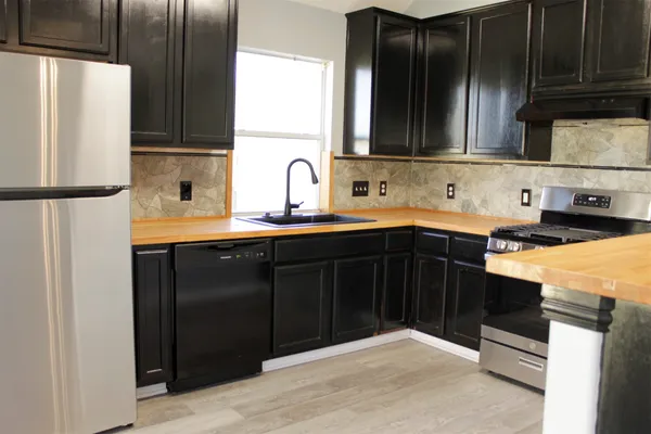 a kitchen with stainless steel appliances granite countertop a refrigerator and a sink
