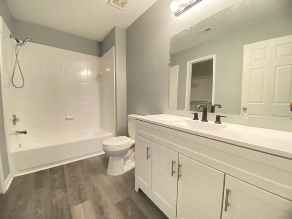 a bathroom with a double vanity sink toilet and shower