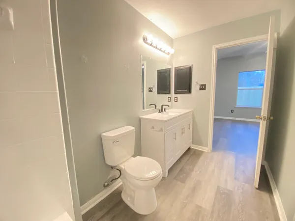 a spacious bathroom with a toilet a sink and mirror