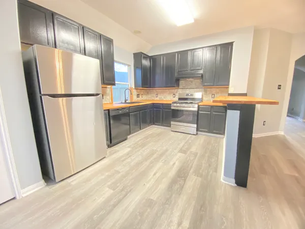a kitchen with granite countertop a refrigerator and a sink