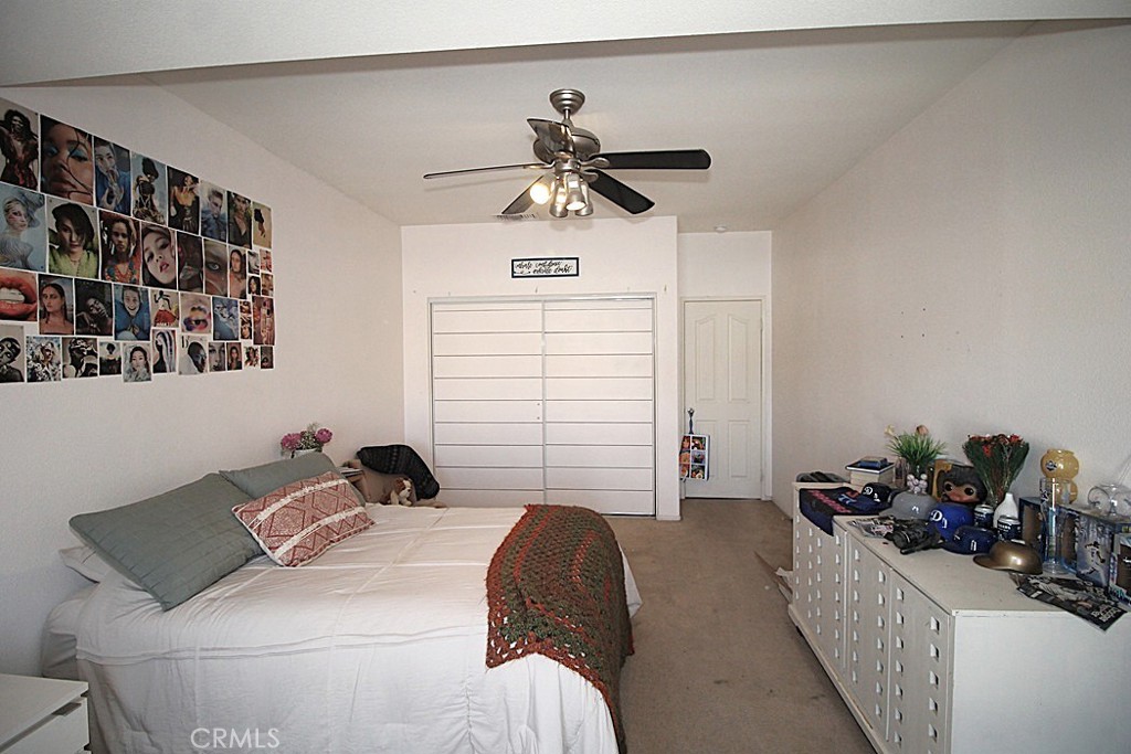 924 Condor Street Barstow, CA 92311 - Photo 16 of 52 a bedroom with a bed and a chandelier