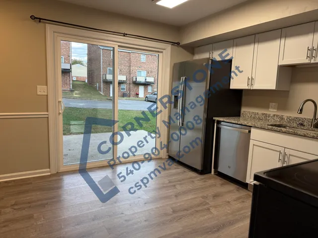 a kitchen with stainless steel appliances granite countertop a refrigerator a stove and a wooden floors