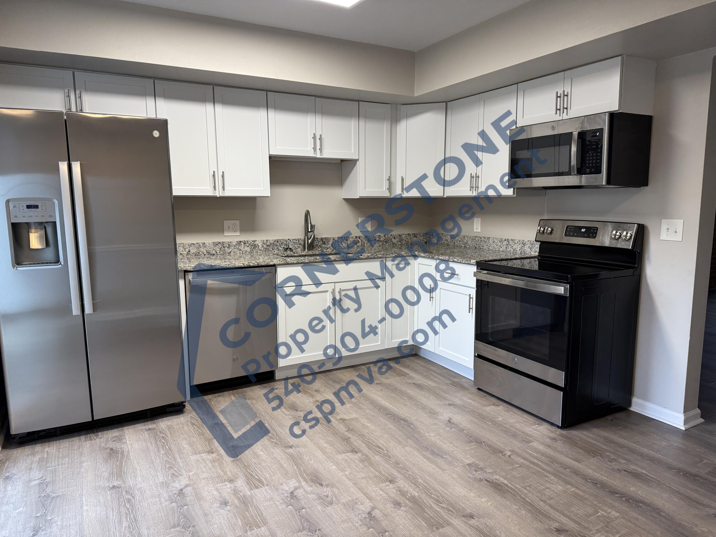 1609 19th Street Northeast, Unit 3 Roanoke, VA 24012 - Photo 5 of 12 a kitchen with stainless steel appliances granite countertop a stove a refrigerator and a microwave
