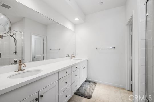 165 Frame Irvine, CA 92618 - Photo 20 of 37 a bathroom with a double vanity sink and mirror with toilet