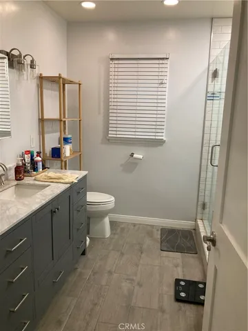 a bathroom with a granite countertop sink toilet and mirror