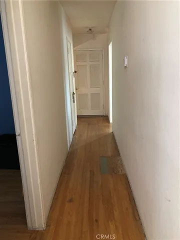 a view of a hallway with wooden floor and closet
