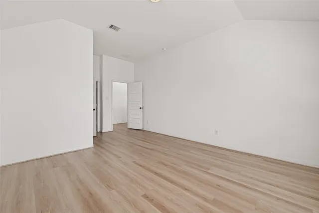 a view of an empty room with closet and a window