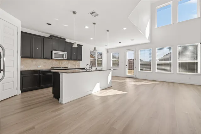 an empty room with wooden floor a fireplace and windows