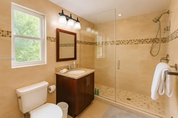 a bathroom with a granite countertop sink toilet and shower