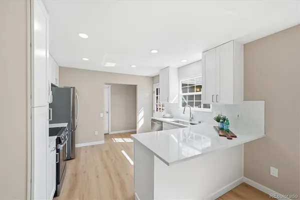 a kitchen with stainless steel appliances a sink stove and refrigerator
