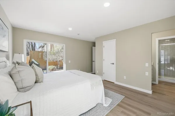 a bedroom with a large bed and wooden floor
