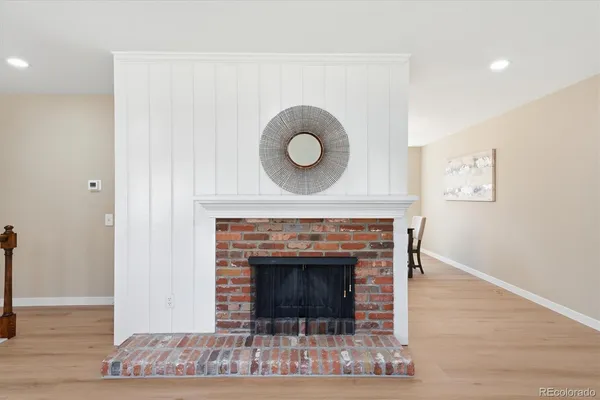 a living room with a fireplace and wooden floor