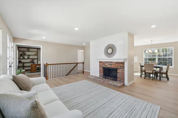 a living room with furniture a fireplace and a floor to ceiling window