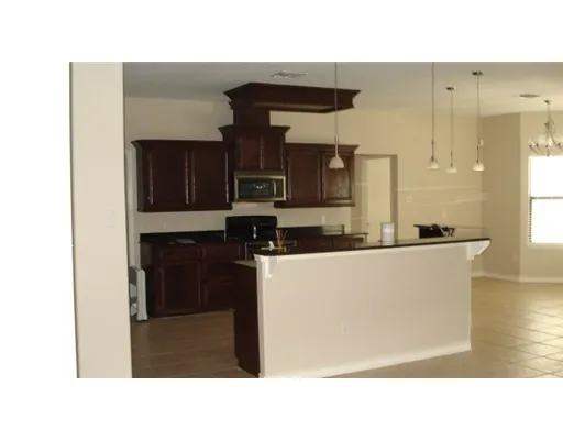 a open kitchen with a sink and a refrigerator