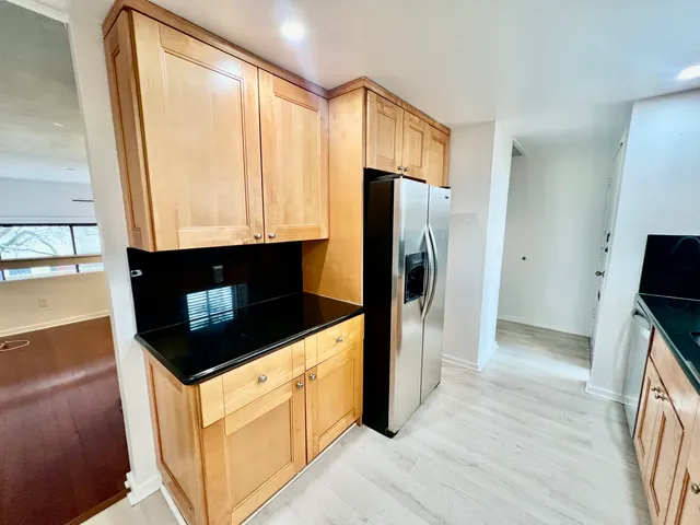 a kitchen with stainless steel appliances granite countertop a refrigerator a stove and a sink