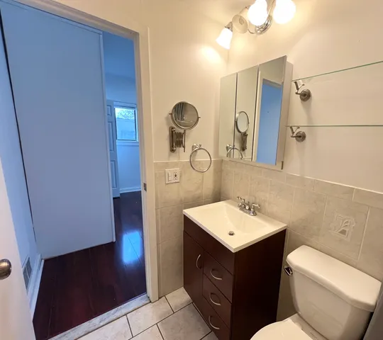 a bathroom with a sink vanity mirror and toilet