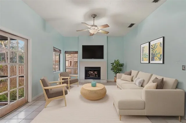 a living room with furniture a fireplace and a large window