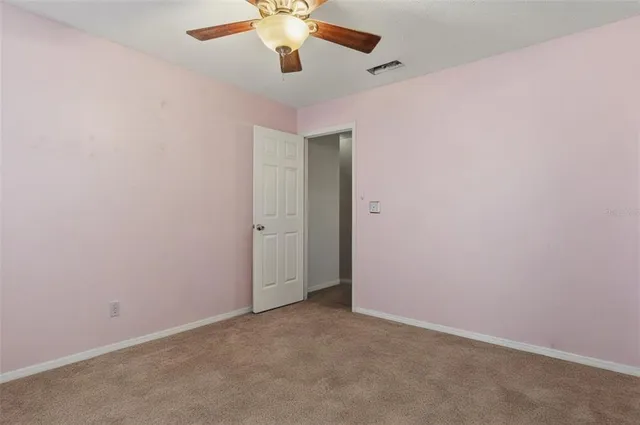 an empty room with a chandelier fan and a ceiling fan