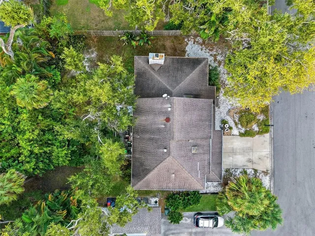 an aerial view of a house with a yard and large tree
