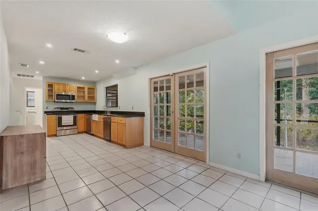 a large kitchen with stainless steel appliances granite countertop a refrigerator and a sink